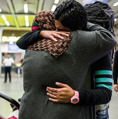 A man and woman embracing in an airport. Photo © Safe Passage
